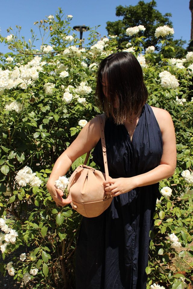 Woman carrying the Sunday sphere bag among white roses